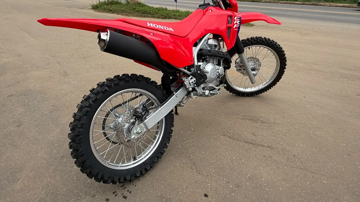 Detalhe traseiro da Honda CRF 300F zero km: escapamento, balança e pneus de trilha