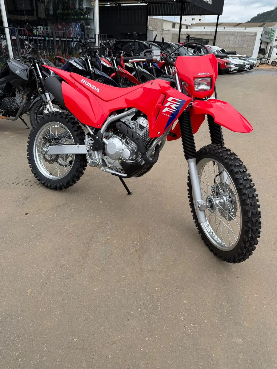 Honda CRF 300F zero km vermelha, vista frontal, em frente à loja BR Motos